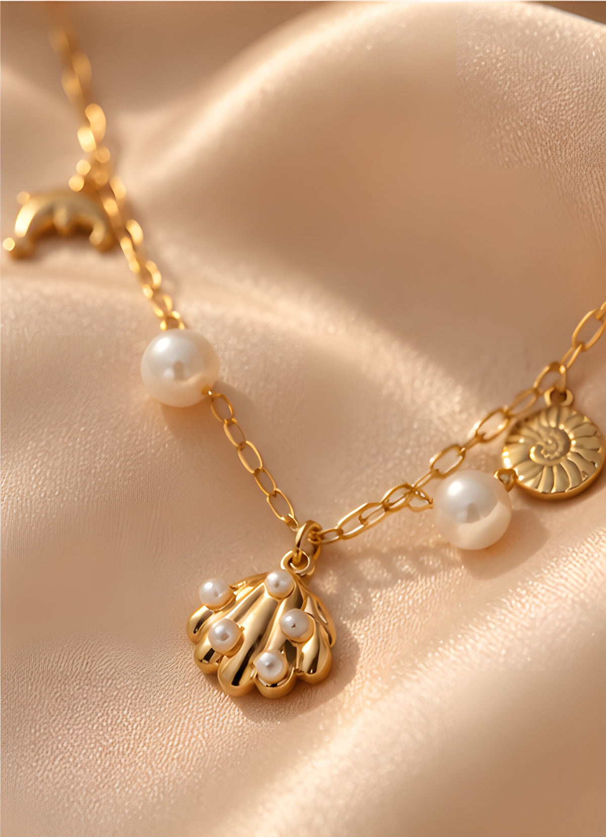 Close-up of pearl and shell charms on Vioras gold necklace