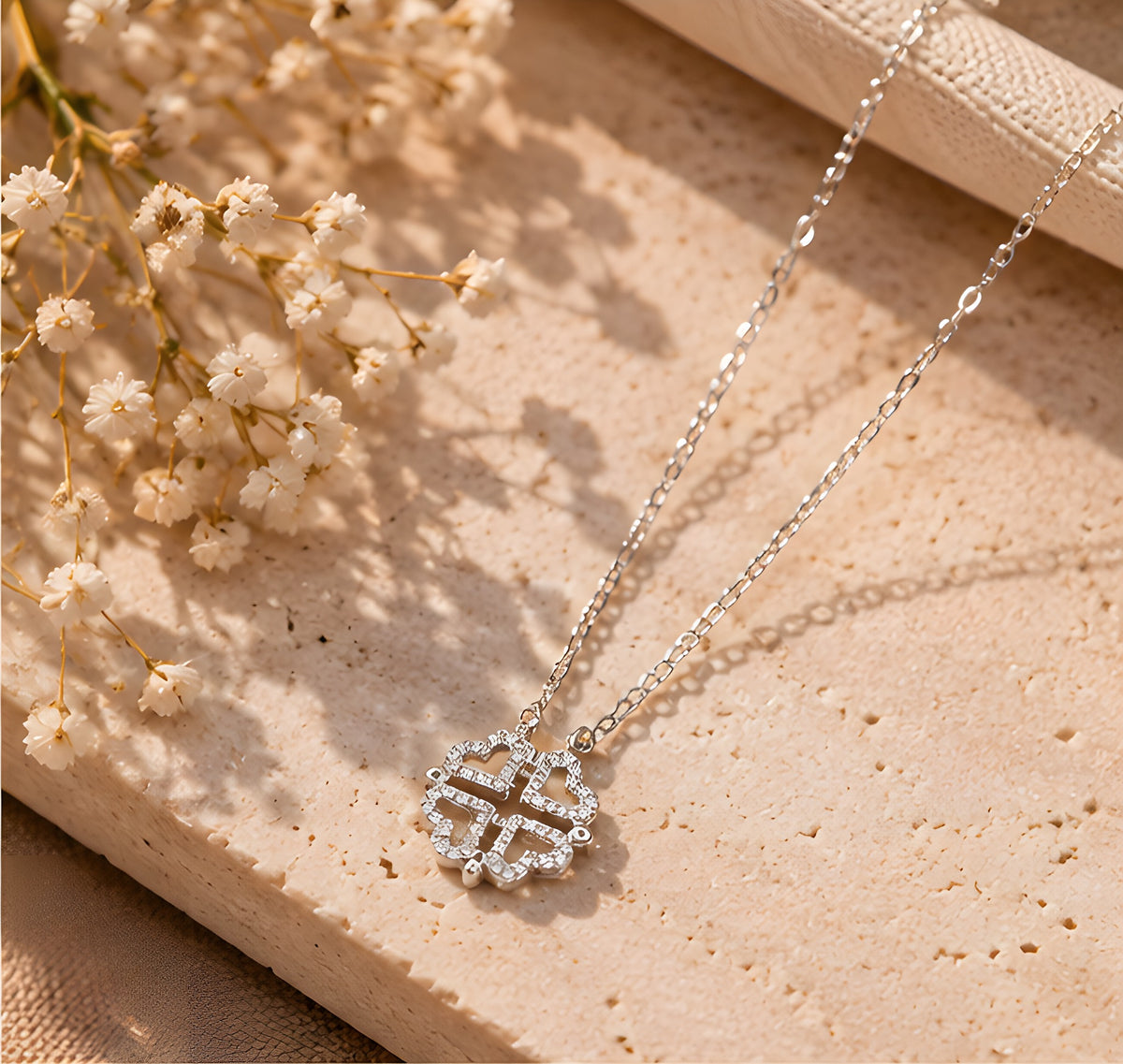 Silver clover necklace product flat lay