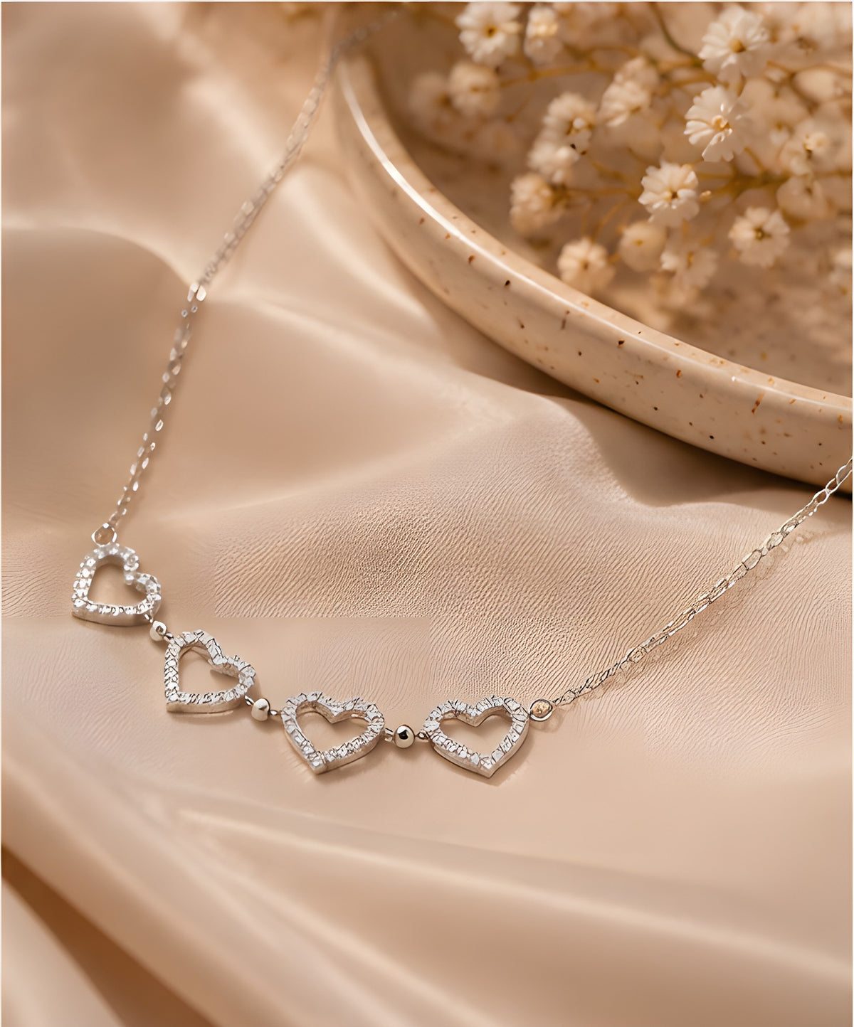 Silver heart necklace on satin background