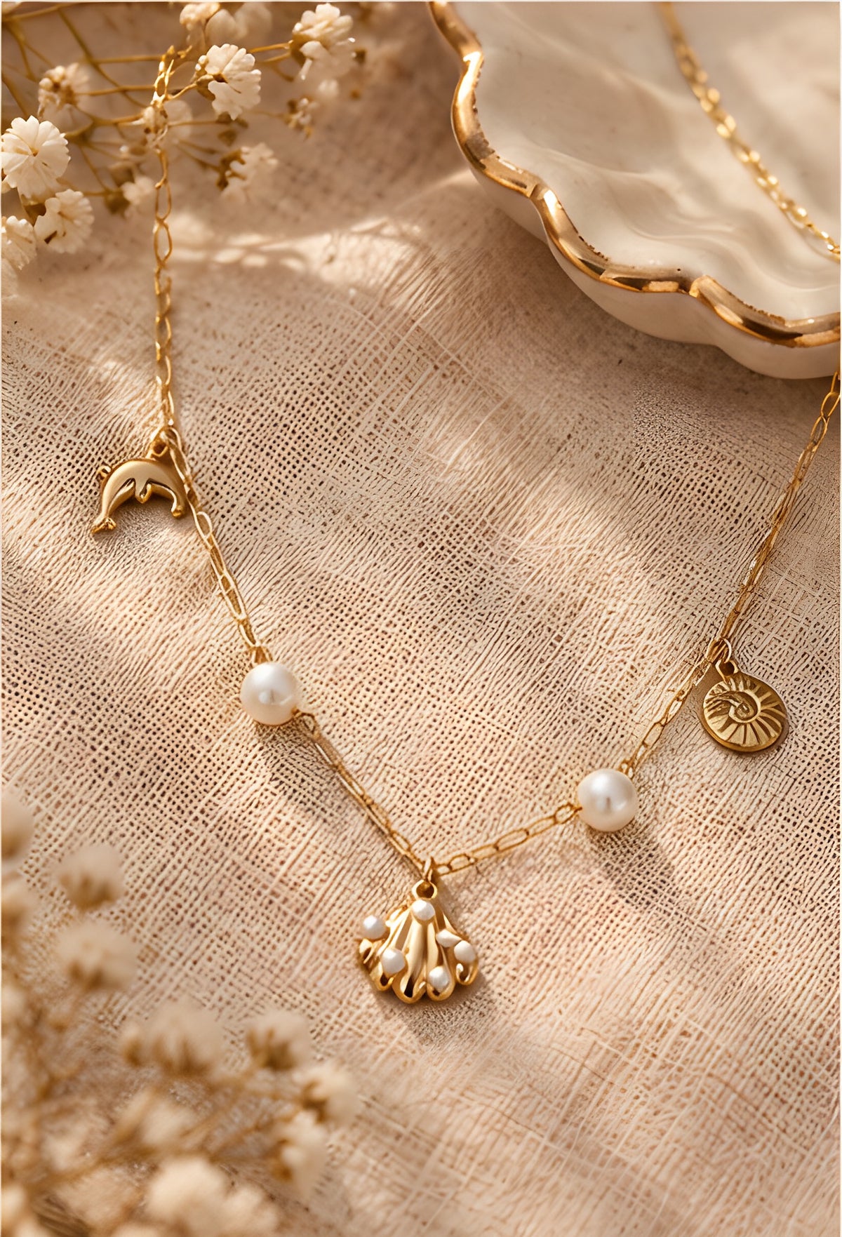 Vioras Ocean Charm Pearl Necklace styled on textured linen