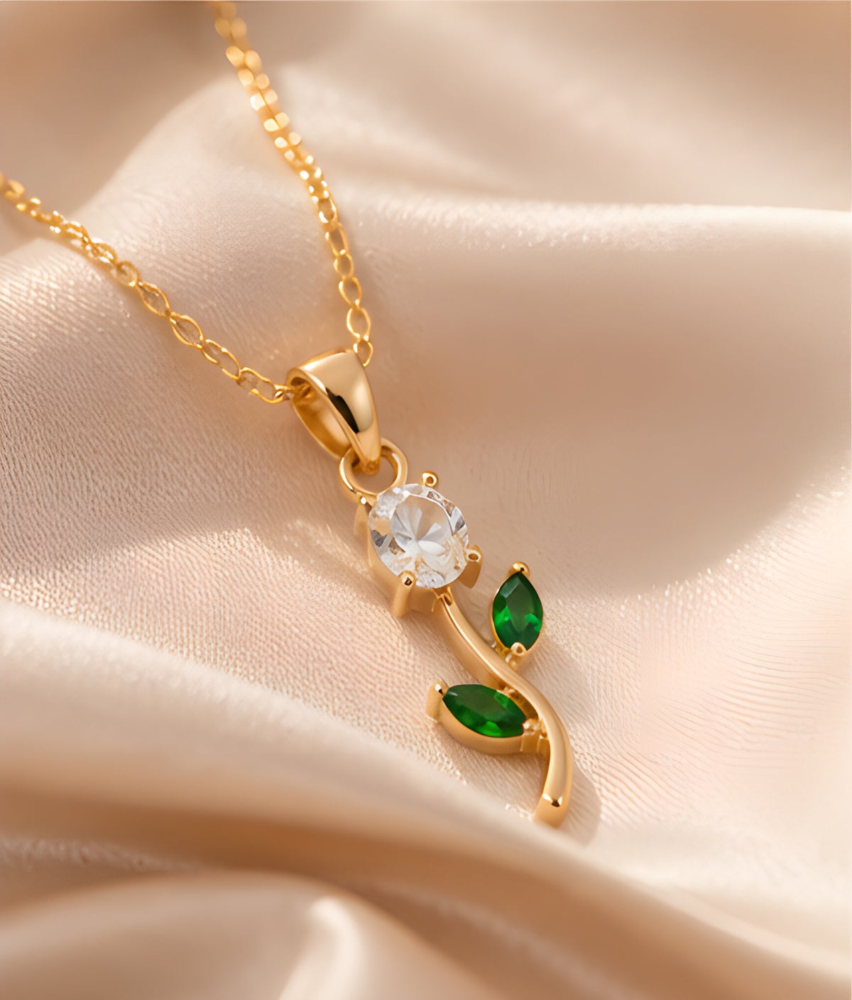 Close-up of white gemstone tulip pendant with green leaves